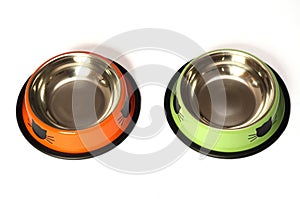 A pair of green and orange pet bowls with rubber ring stoppers white backdrop photo
