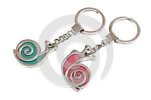A pair of green and red snails keychains against a white backdrop