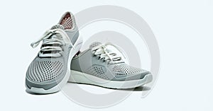 A pair of grey shoes on white background. Comfortable shoes with pore. Breathable rubber shoes. Footwear