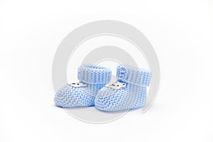 A pair of handmade blue knitted baby booties, isolated on white background. Newborn clothing and pregnancy. Fashion