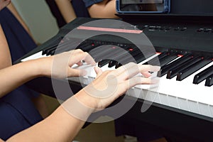 A pair of hands playing a musical keyboard piano organ instrument