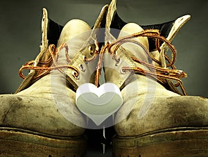 Pair of heavy military boots and white heart.