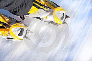 Pair of high mountain boots with crampons in the snow.