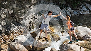 Pair of hikers crossing the rocky terrain, giving high five