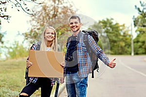 A pair of hitchhikers stand on the road