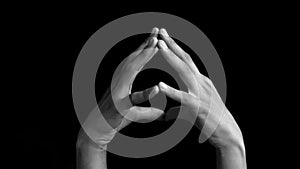 Pair of human hands coming up and showing demonstrating Hakini Yoga Mudra Hand Gesture isolated on black background.
