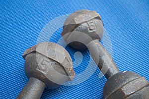 Pair of iron dumbbell 5 kilograms on blue yoga mat