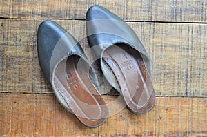 a pair of Javanese sandals which are often called slippers placed on wood photo