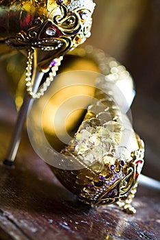 Pair of jeweled golden shoes in antique interior