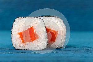 Pair of jtasty apanese rolls with salmon, rice and nori on sky b