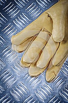 Pair of leather safety gloves on corrugated metal plate construc