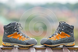 A pair of leather trekking hiking winter boots on blurred background