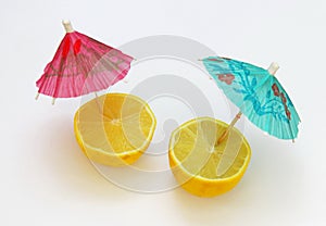 A pair of lemons with cocktail umbrellas