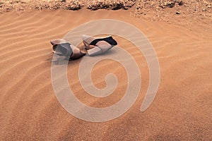 Pair of lost women shoes on the sand in the dunes