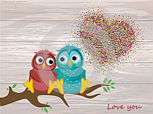 A pair of lovely owls in love, sit on a branch. Colorful confett