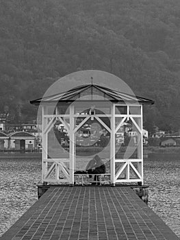Pair of lovers under a gazebo on the pier of a lake