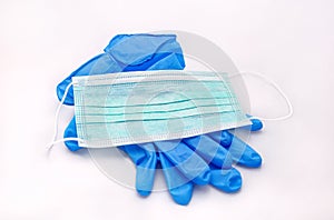 Pair of medical blue latex protective glove and green mask on white background. Protection equipment against virus, flu.
