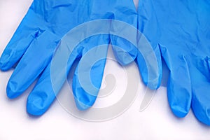 Pair of medical blue latex protective gloves on white background. Protective disposable gloves against the spread of virus, flu.