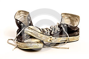 Pair of Men`s or Teenager`s Worn Out Dirty High Top Black and White Tennis Shoes on White Background