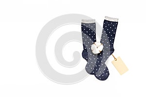 Pair of modern trendy women`s cotton polka dot socks with cotton flower and price tag on white background. Fashionable socks stor
