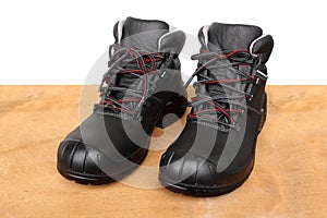 Pair of new black work boots made of genuine leather with a reinforced cape, the concept of special shoes for different