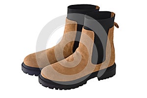 A pair of new fashionable boots with thick tractor soles. Suede leather shoes. Beige brown boots  on white background