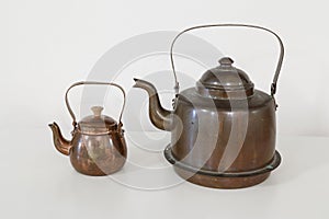 Pair of old fashioned copper kettles on white background