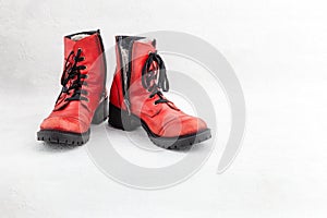 Pair of old leather red discarded boots with laces