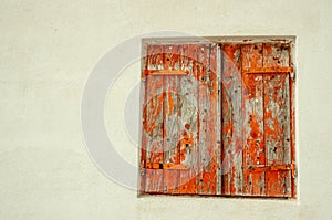 Pair of, old, wood, closed, window shutters, with peeling, red paint