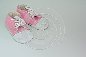 A pair of pink baby girl shoes on white background