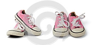 Pair of pink children`s textile sneakers with white laces isolated on a white background