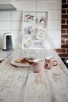 A pair of pink coffee cups. Kitchens in light colors.
