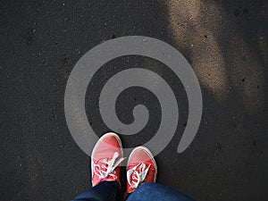 a pair of pink sneakers on the wet asphalt