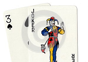 Pair of playing cards showing a joker and a three.