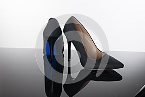 pair of pointed woman shoes with black soles blue high heels