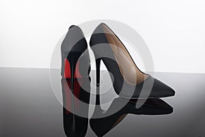 Pair of pointed woman shoes with black soles red high heels