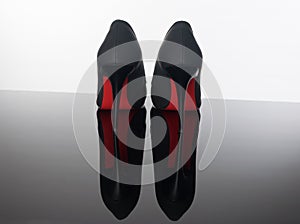 Pair of pointed woman shoes with black soles red high heels