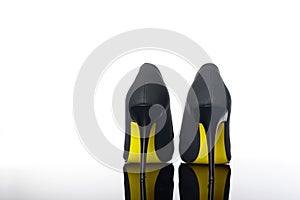 pair of pointed woman shoes with black soles yellow high heels