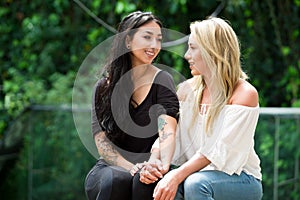 A pair of proud lesbian in outdoors looking at each other, in a garden background