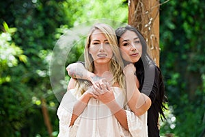 A pair of proud lesbian in outdoors looking at each other, in a garden background