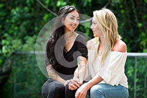 A pair of proud lesbian in outdoors looking at each other, in a garden background photo