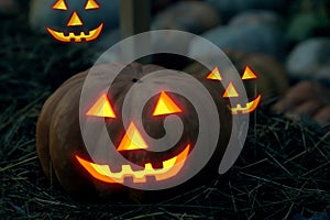 A pair of pumpkins carved face, terrifying burning in the dark, frightens the decor of Halloween