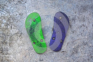 a pair of purple and green flip-flops placed upside down