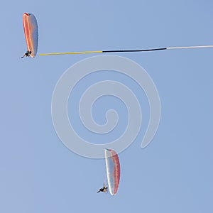 Pair of reckless pilots performs aerial acrobatics on board paramotors with the use of a banner