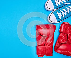 Pair of red boxing gloves and blue textile sneakers