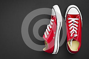 Pair of red classical gymshoes on dark background