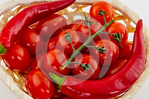 Pair of red curved pod spicy branch of tomato cherry a lot of vegetables close-up