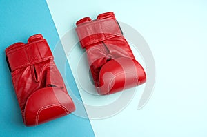 Pair of red leather boxing gloves on a blue background