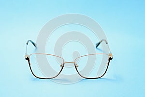 Pair of red plastic-rimmed eyeglasses on a blue background