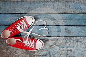 A pair of red retro sneakers on a blue wooden background, laces